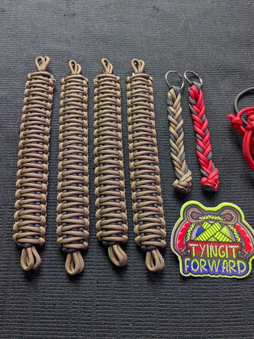 Paracord keychains and a colorful patch on a dark fabric background.