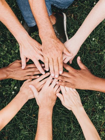 An image of a team of people's hands touching Adventures of the Heart and Mind