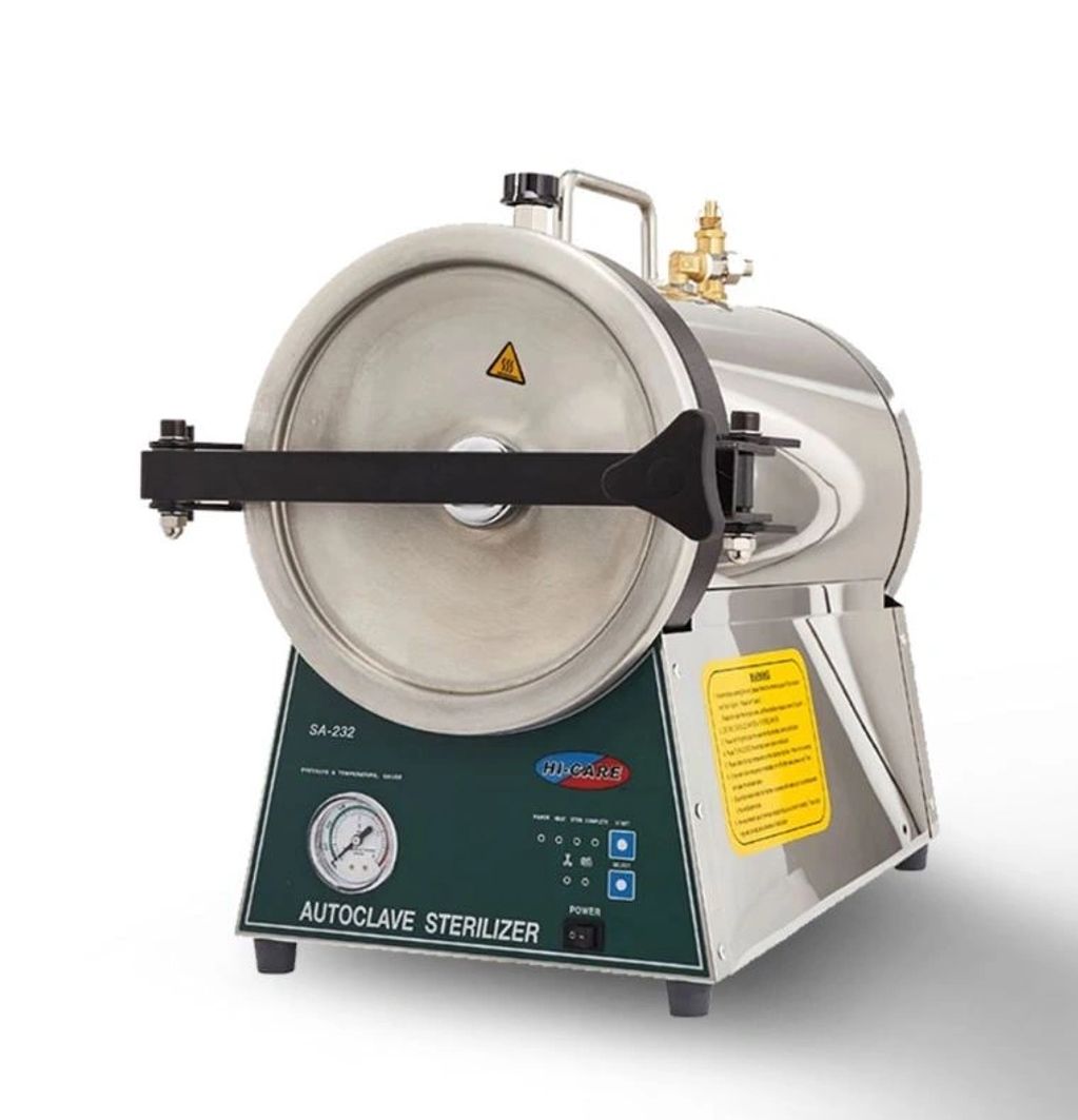A tabletop autoclave sterilizer with control panel and pressure gauge.