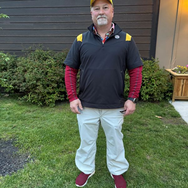 Man standing on grass wearing casual sportswear.
