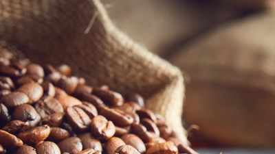 Roasted coffee beans spilling from a hessian sack