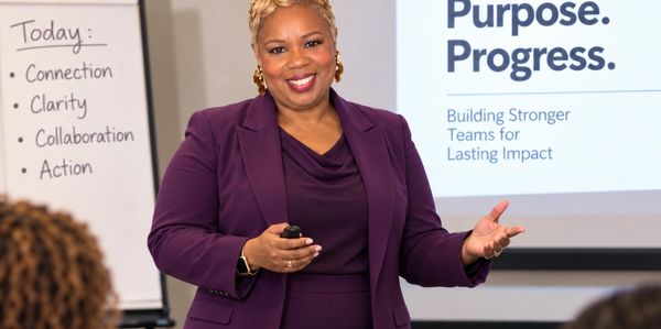 Confident woman leading a presentation on teamwork and progress.
