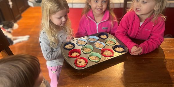 Children excitedly looking at a tray of homemade cookie dough cups.