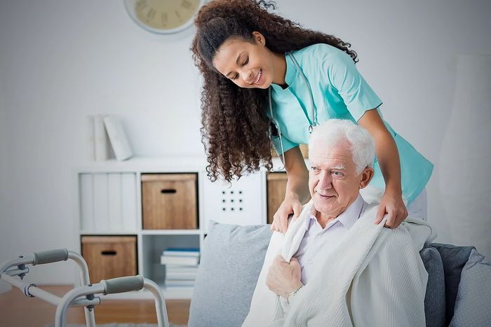 A friendly caregiver attending an elder man.