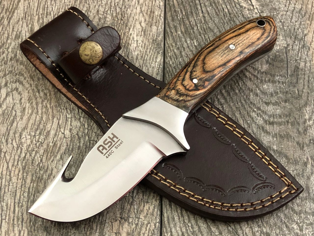 A 8 inch gut hook bushcraft knife made of 440C steel is a knife designed for hunting and outdoor activities. The gut hook blade shape is specifically made for gutting game animals, allowing for a precise and efficient process. 440C steel is a high-carbon stainless steel known for its good edge retention, corrosion resistance, and toughness. This type of knife can be used for various tasks in the wilderness such as preparing food, making shelter, or starting a fire. As with any knife, it is important to regularly maintain and sharpen the blade to ensure its effectiveness and safety during use.