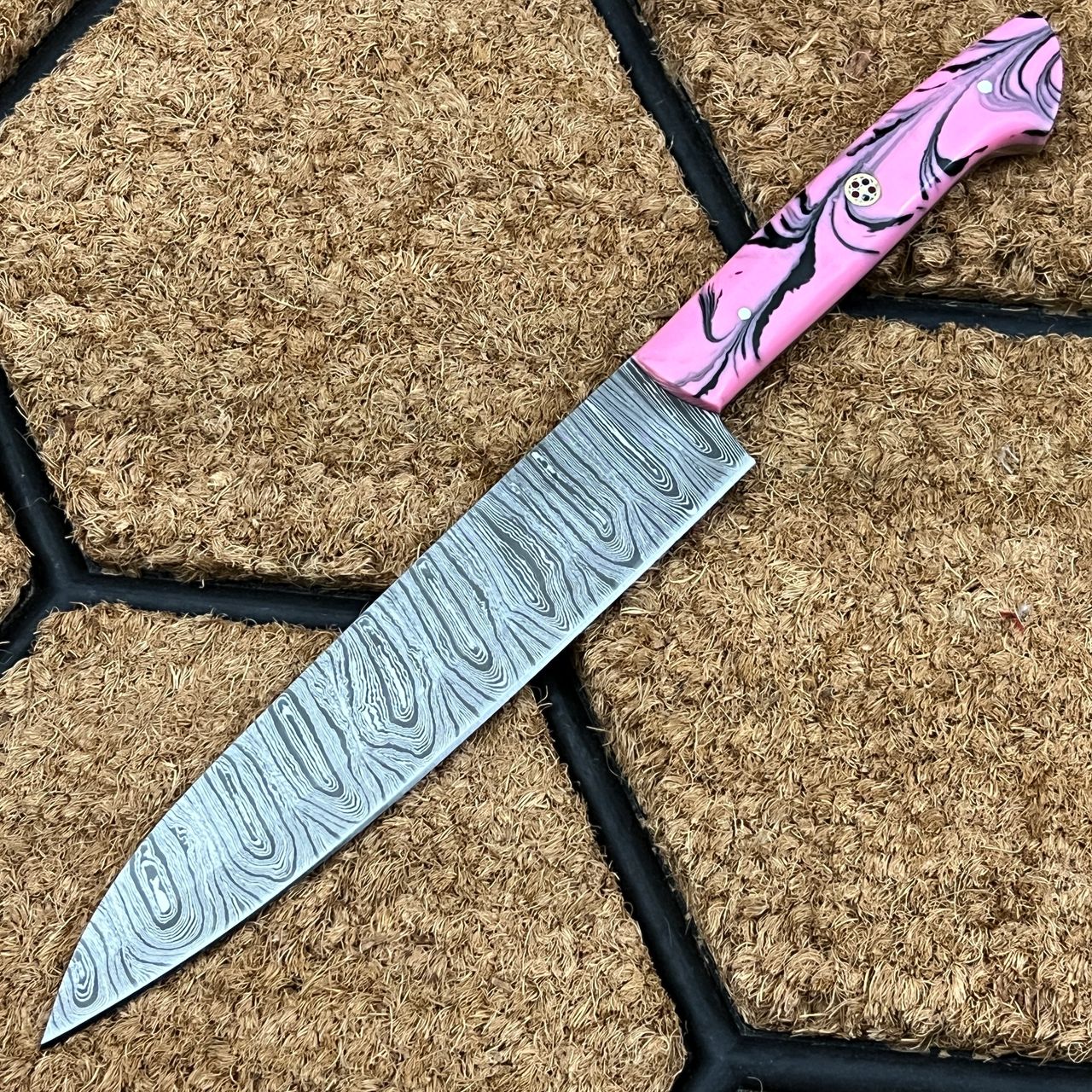 The Santoku Knife is made of Damascus steel and is precisely sharpened to make clean cuts every time. This knife can be used for a variety of tasks around the kitchen. Cutting, slicing, and chopping are the "three uses" referenced by the term.  Whether you're dicing, mincing, or slicing vegetables, poultry, roasts, and more, you'll have great control with a Santoku knife. When slicing into meat, the granton edge's grooves fill with fat and fluids, increasing the blade's surface area and making quick work of the task.