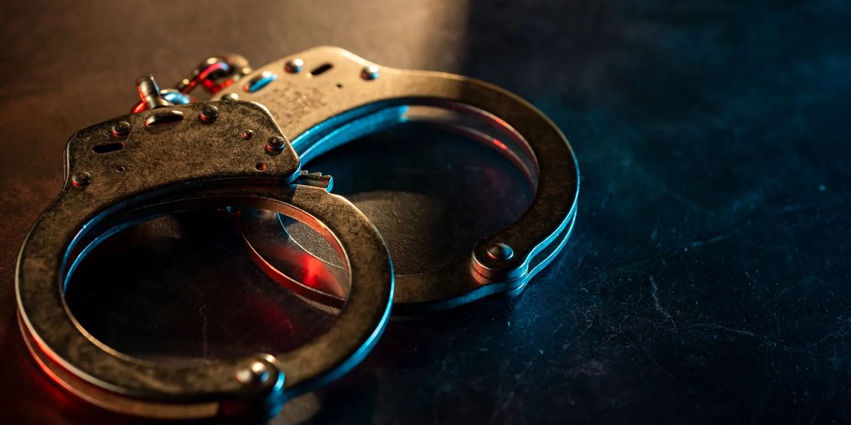 silver handcuffs lying on a black surface