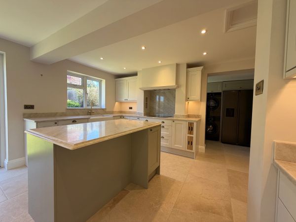 Modern kitchen with marble countertops and integrated appliances.