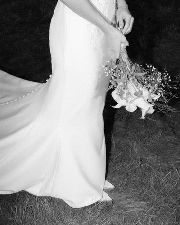 Bride in elegant gown holding a bouquet of flowers.