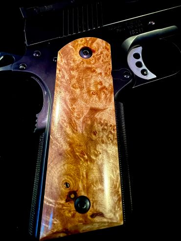 Close-up of a gun with a wooden grip.