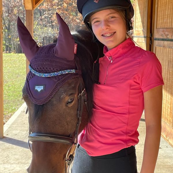 Girl standing next to horse