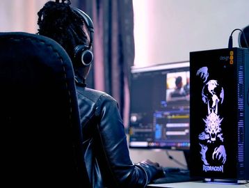 Person editing video on a computer with headphones on.