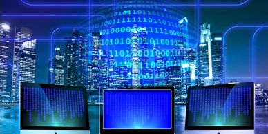 Three computers with digital binary code overlay in a cityscape.