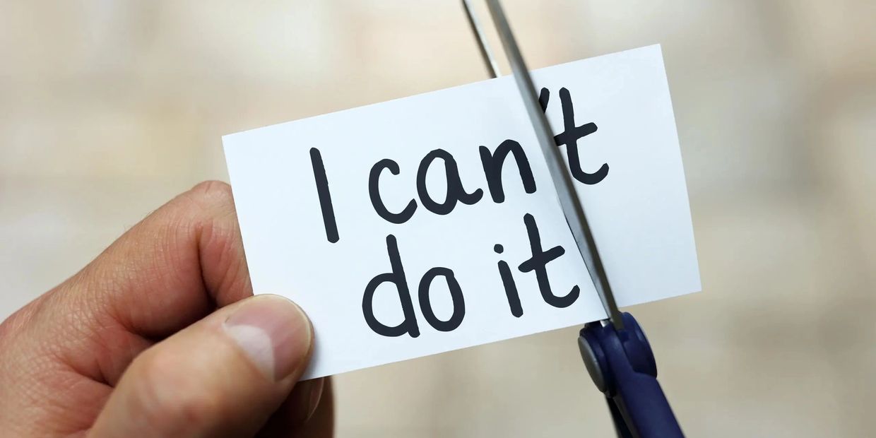 Cutting "can't" to form "I can do it" on paper.