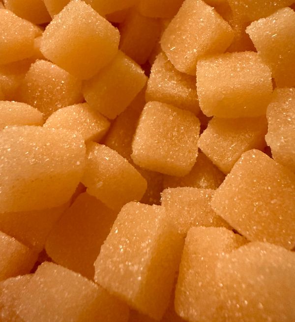 Close-up of orange sugar-coated gummy cubes.