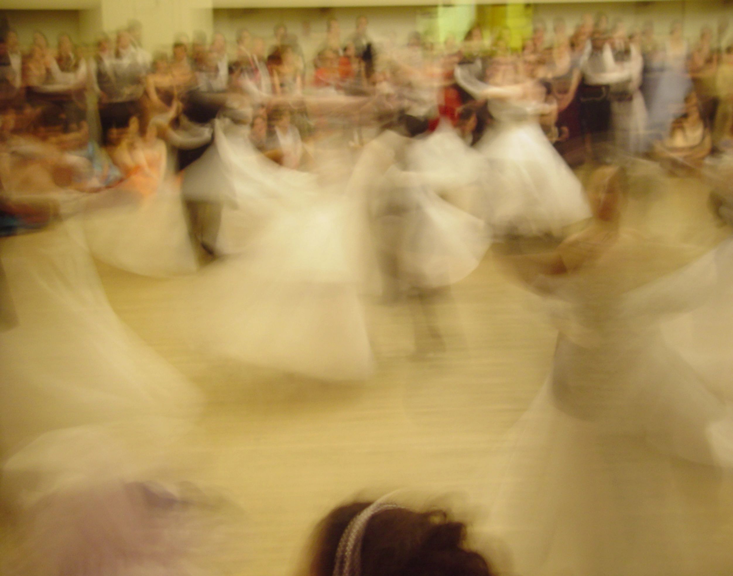 Slow motion photo capture of dancers in white ballgowns and men in black tuxedos