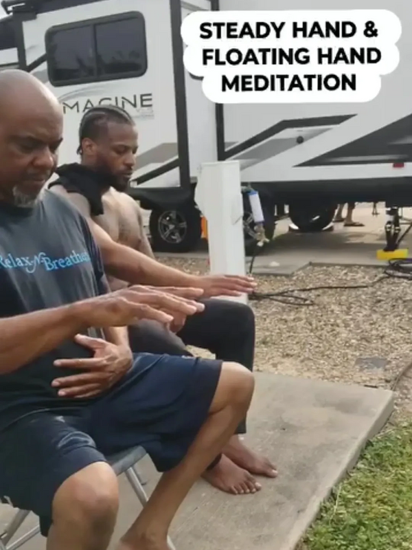 Two men practicing steady hand and floating hand meditation outdoors.