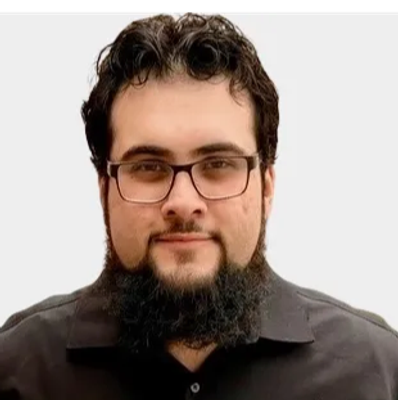 Man with glasses and a beard wearing a black shirt.