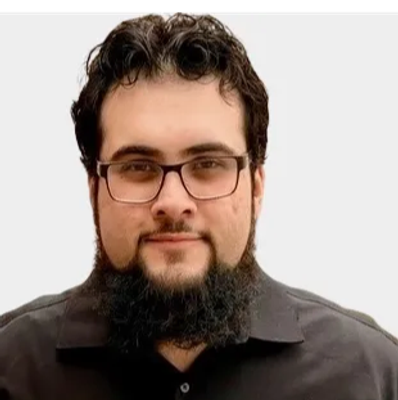 Man with glasses and a beard wearing a black shirt.