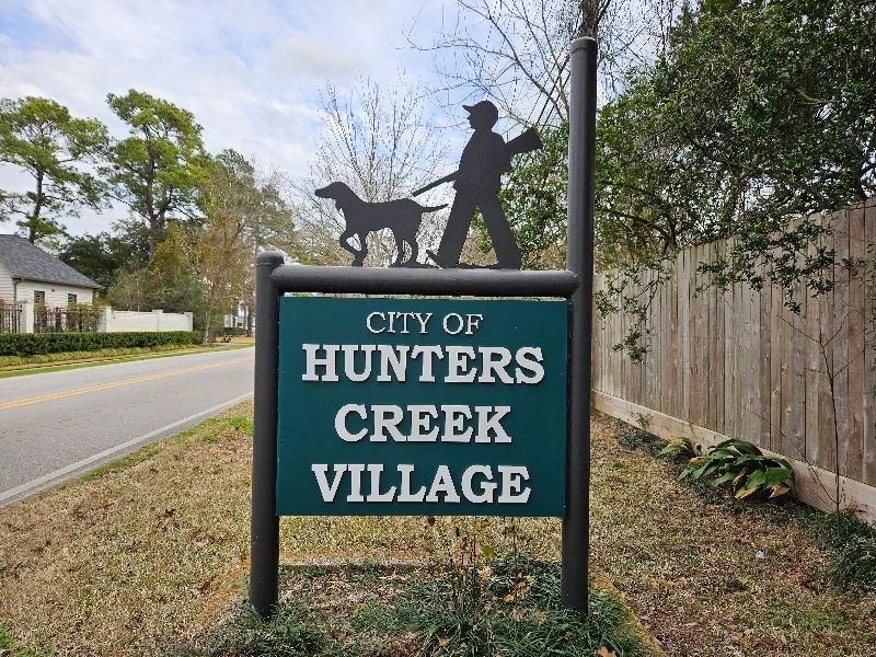 City of Hunters Creek Village sign in Houston, Texas. Iron sign with a hunter and dog.