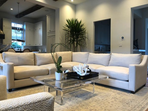 A white linen fabric sectional couch with large plant behind it after getting upholstery cleaning. 