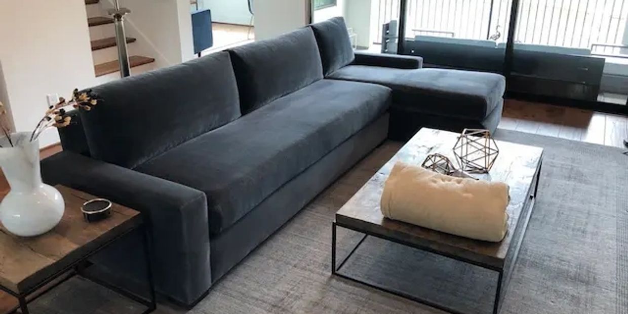Designer blue/gray velvet sectional sofa in living room after professional upholstery cleaning.