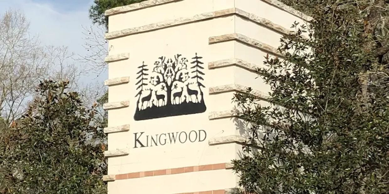 Kingwood entrance sign with trees surrounding it.