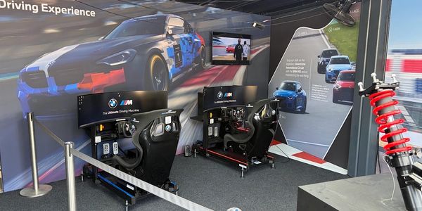 Two BMW racing simulators set up for a driving experience.