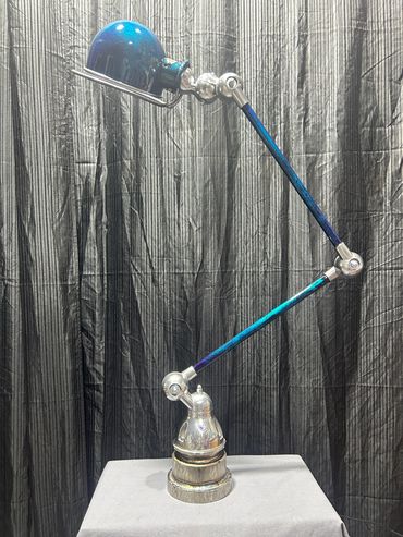 Lampe articulée au design industriel avec bras coloré.