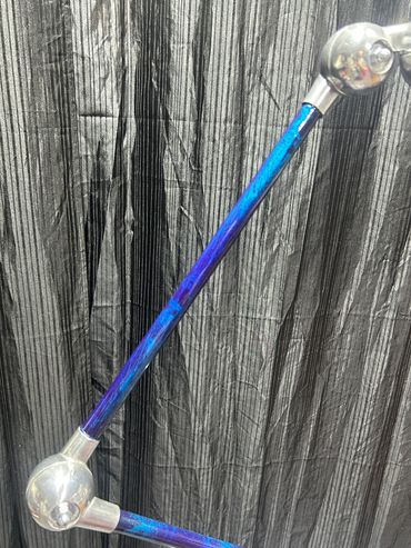 Tige décorative bleue avec des sphères transparentes aux extrémités.