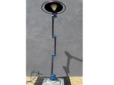 Lampe sur pied avec ampoule exposée et tube métallique bleu.
