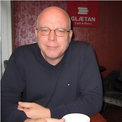 Man with glasses sitting in a cafe.