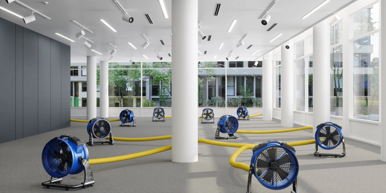 Blue air movers in a large, empty office space.