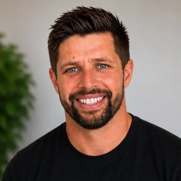 Smiling man with blue eyes and dark hair in a black shirt.