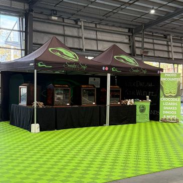 Animal encounter booth with tents and informational signs indoors.