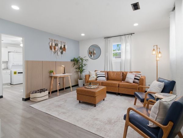 Modern living room with brown leather sofa and wooden decor.
