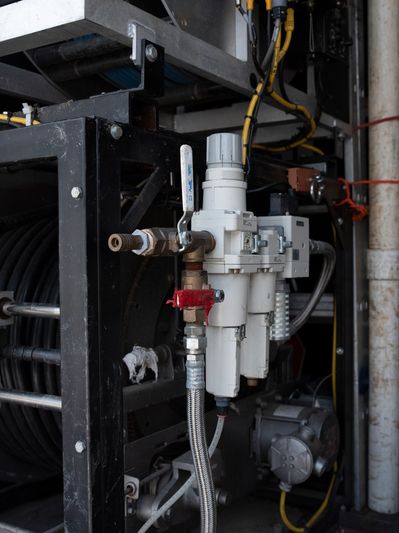 Industrial hose reel and filtration system in a workshop.
