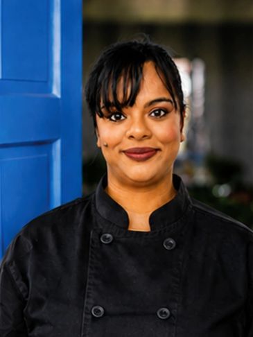 Smiling chef in black uniform.