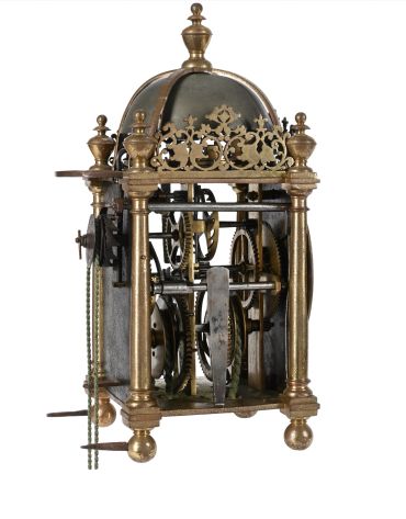 Antique brass clock mechanism with gears and chains.