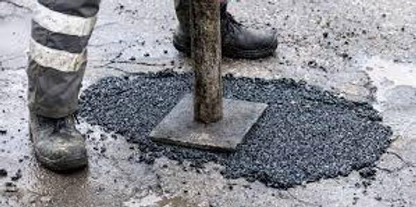 Tamping on a pothole repair