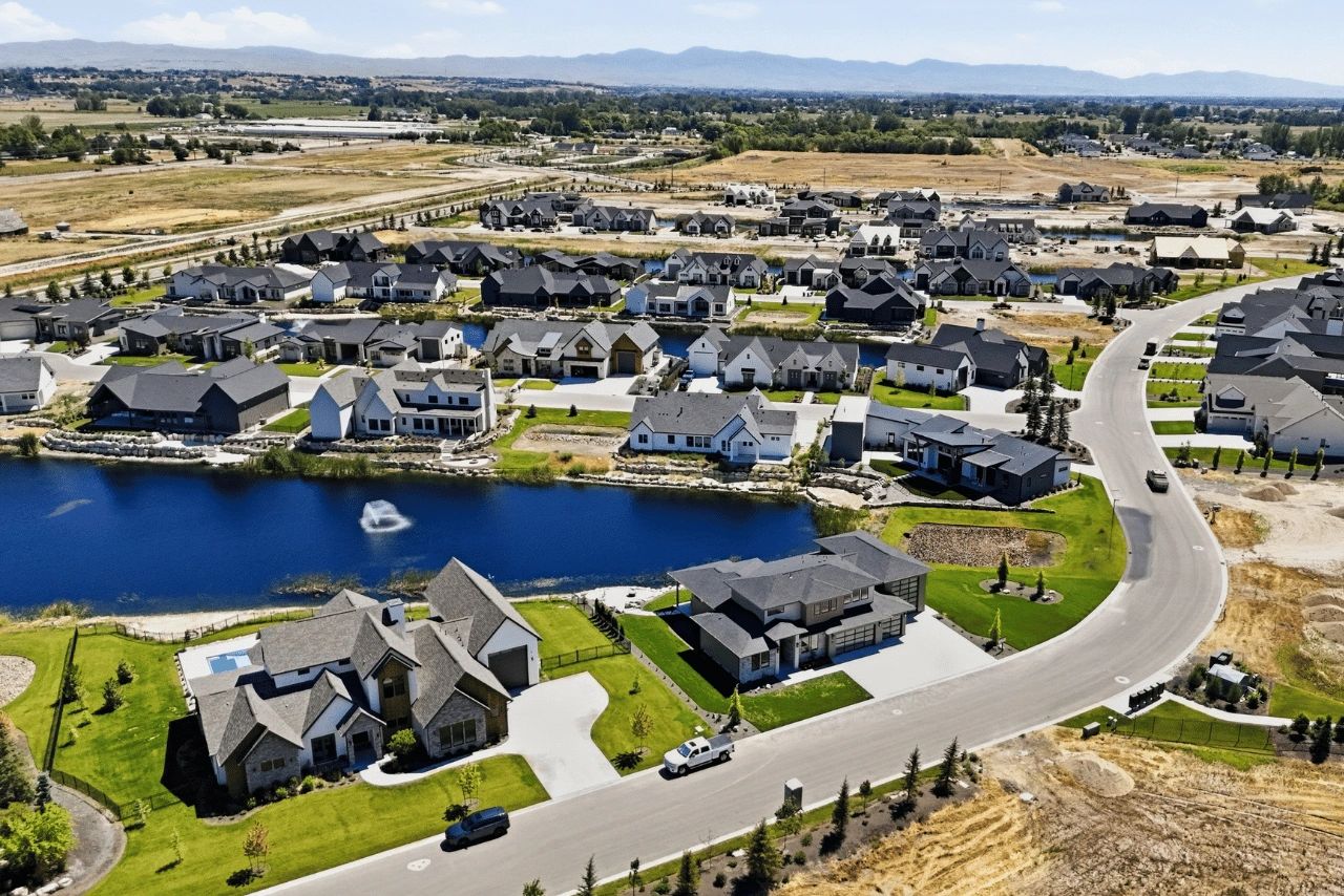 Aerial view of a suburban neighborhood with a lake and houses.