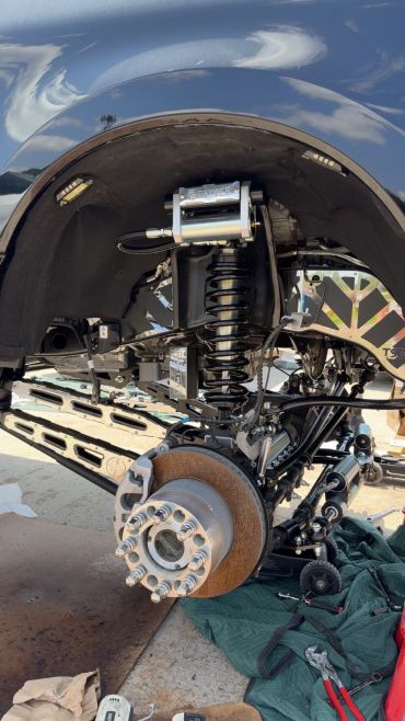 Close-up of a vehicle's suspension and brake system during maintenance.