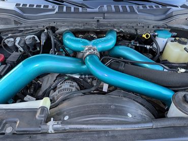 Engine bay with prominent blue aftermarket intake pipes.