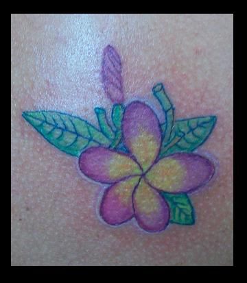 Tattoo of a purple and yellow flower with green leaves
