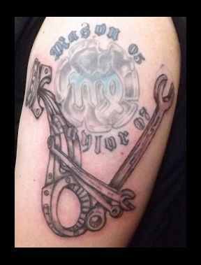Mechanical-themed tattoo with text and wrench design