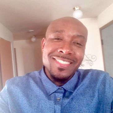 Smiling man in a blue shirt.