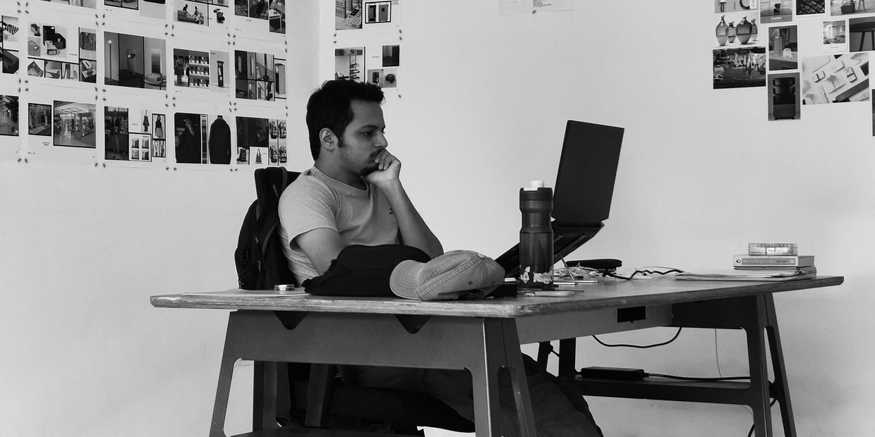 Man working on laptop in a creative workspace.