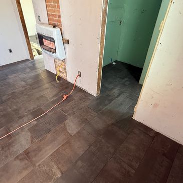 Newly installed dark tile flooring in a partially renovated room.