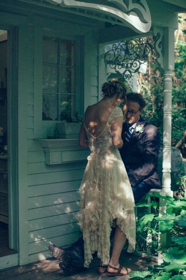 Couple sharing an intimate moment on a porch during a sunny day.