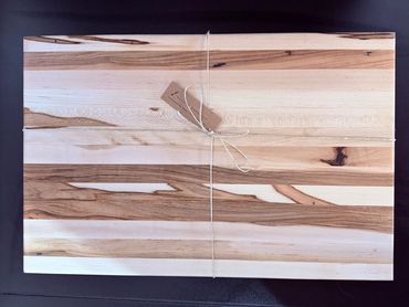Natural wood cutting board with string and tag.